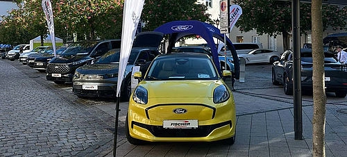 Aufnahme von aufgereihten Autos mit gelben Auto im Vordergrund