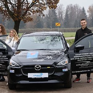 Drei Menschen stehen neben Auto